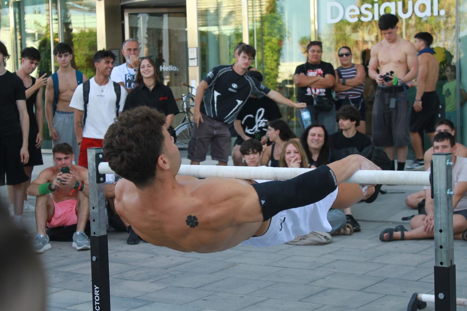 Jose haciendo front lever en una exhibición en la calle